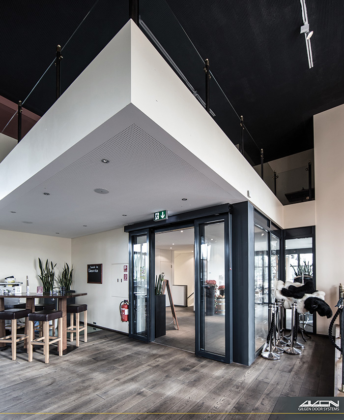 Porte coulissante vitrée à cadre anthracite sous une mezzanine