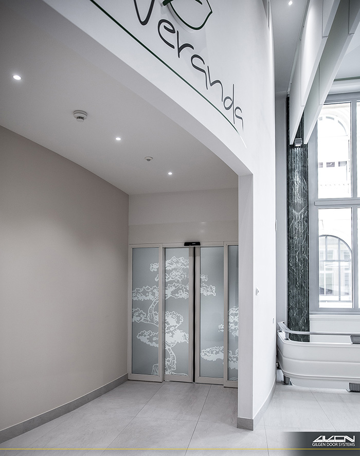 Porte télescopique en verre décoré dans un couloir