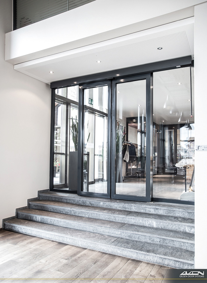 Porte coulissante vitrée à l'entrée d'un hall, en haut d'un escalier